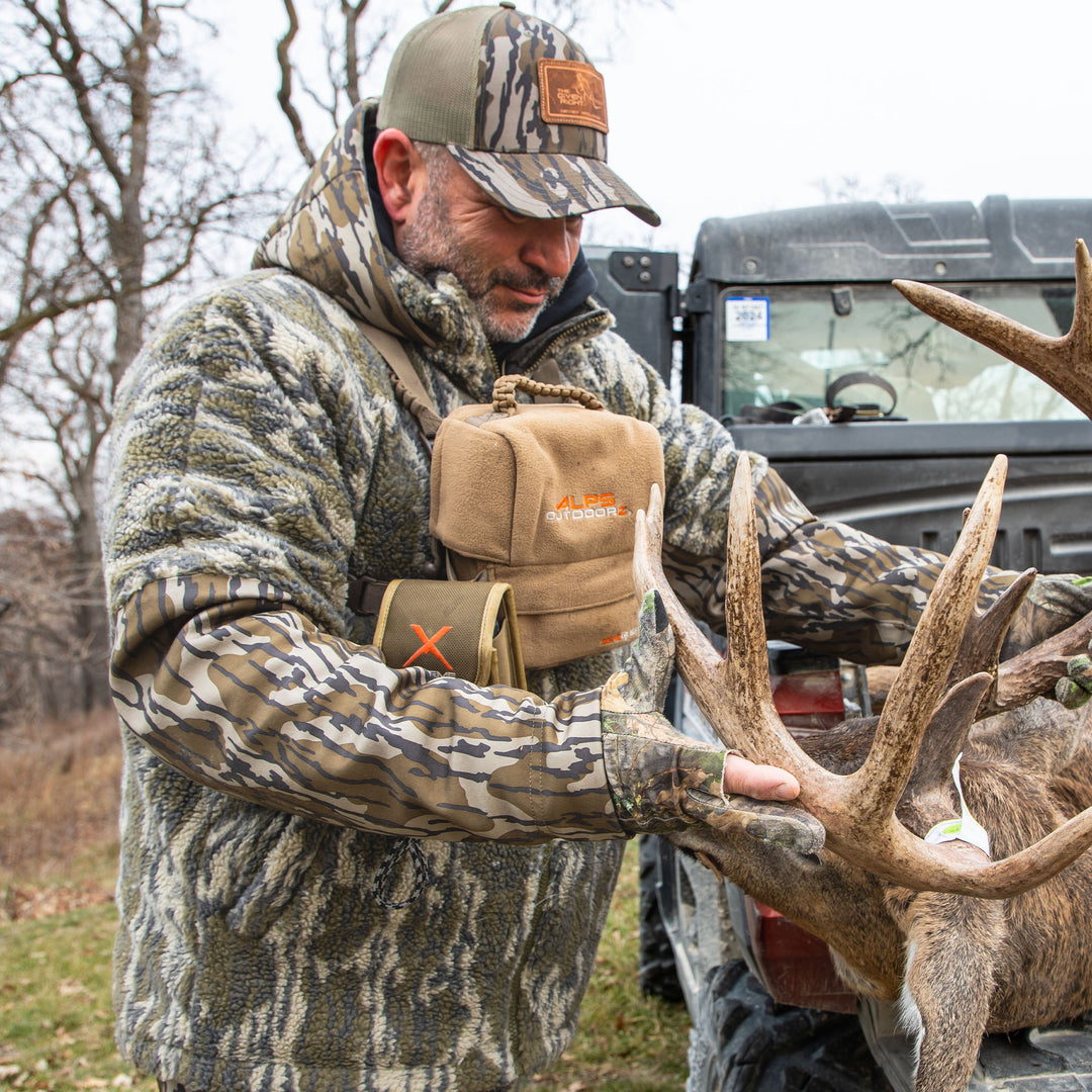 Man admiring a deer after a hunt#color_original-bottomland