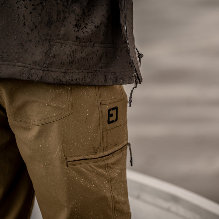 Man standing in the rain on the front of a boat#color_original-bottomland