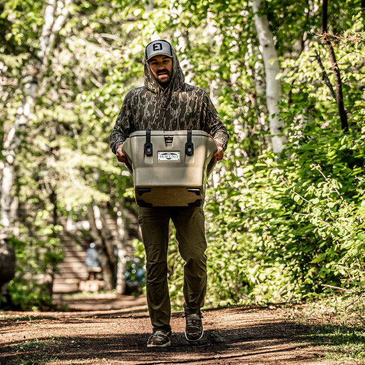 Man carrying a cooler to the lake#color_olive