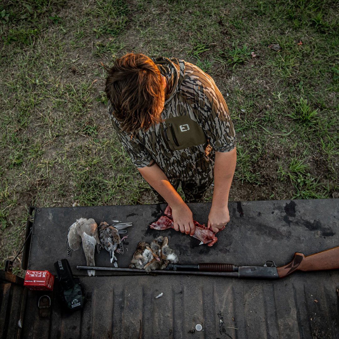 man skinning squirrel in adapt hoodie #color_original-bottomland