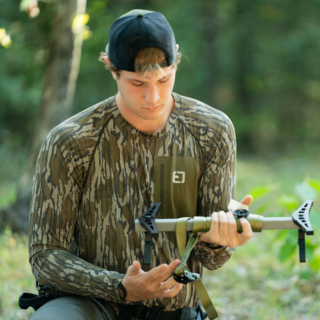 man setting up tree stand #color_original-bottomland