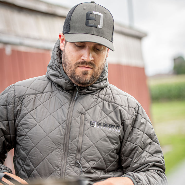 Man in front of a barn wearing a snug jacket#color_ash