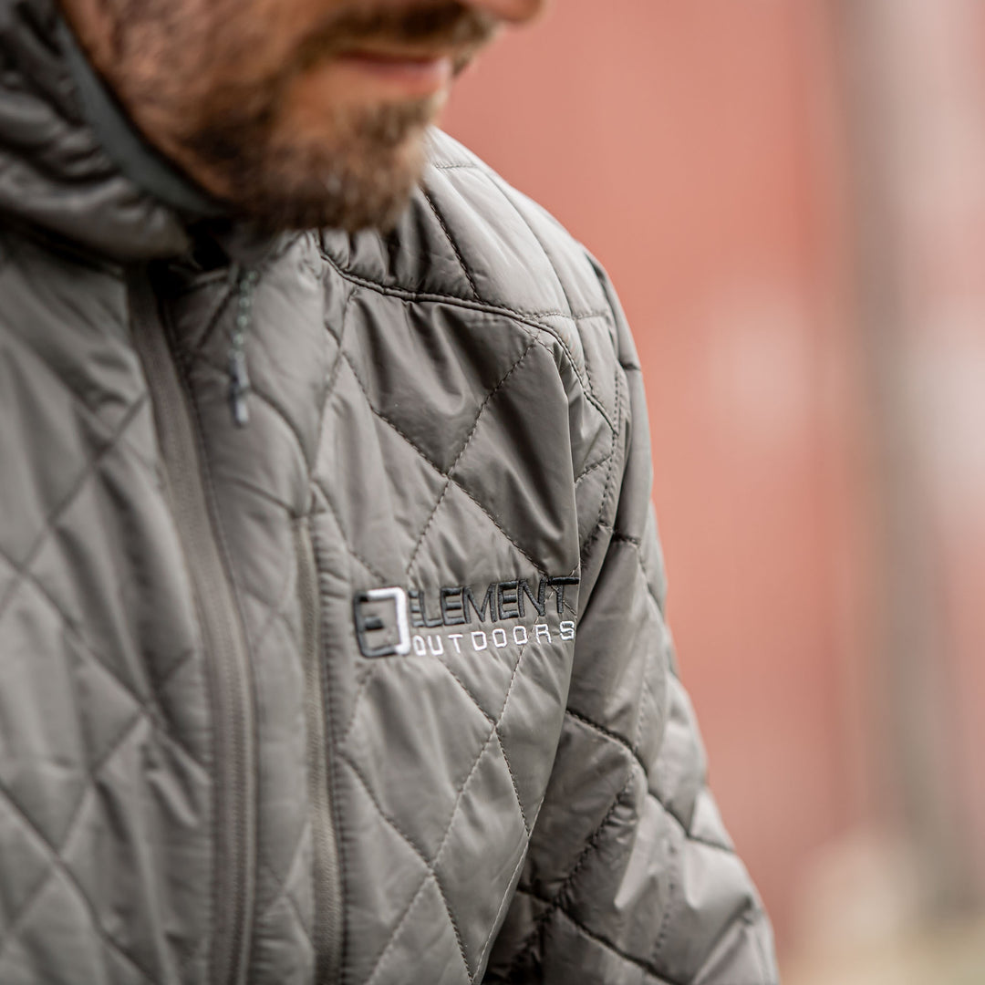 Man in front of a barn wearing a snug jacket#color_ash