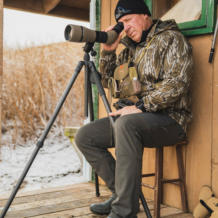 Man glassing from a porch in Alaska wearing out peak pant #color_coyote