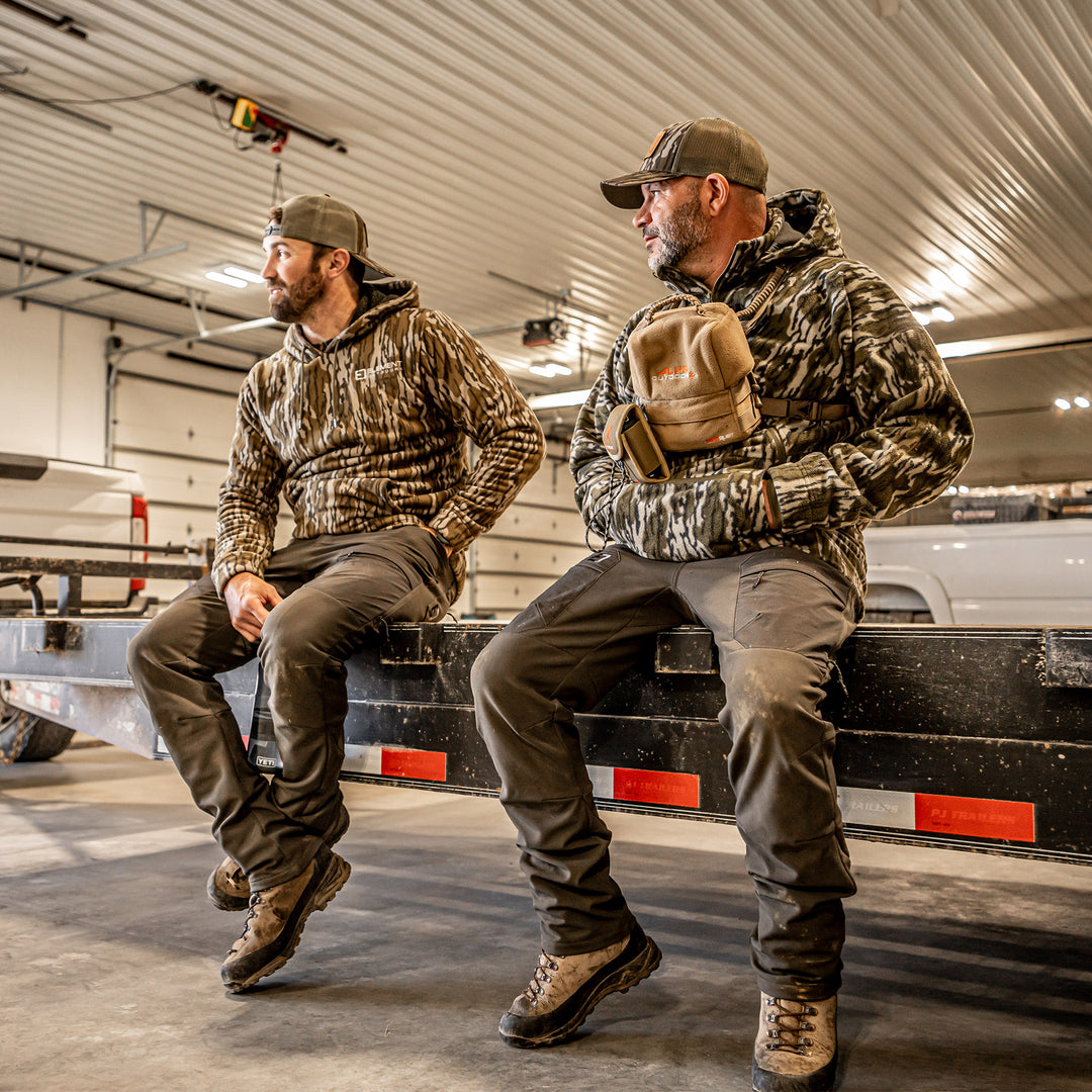 Two guys sitting on the back of a truck wearing peak pants#color_original-bottomland